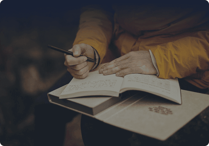 An author writing notes in a book
